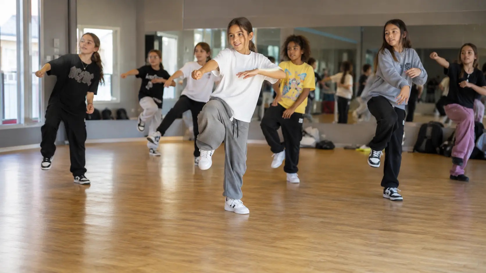 Grupo de niñas y niños bailando en una clase de baile infantil