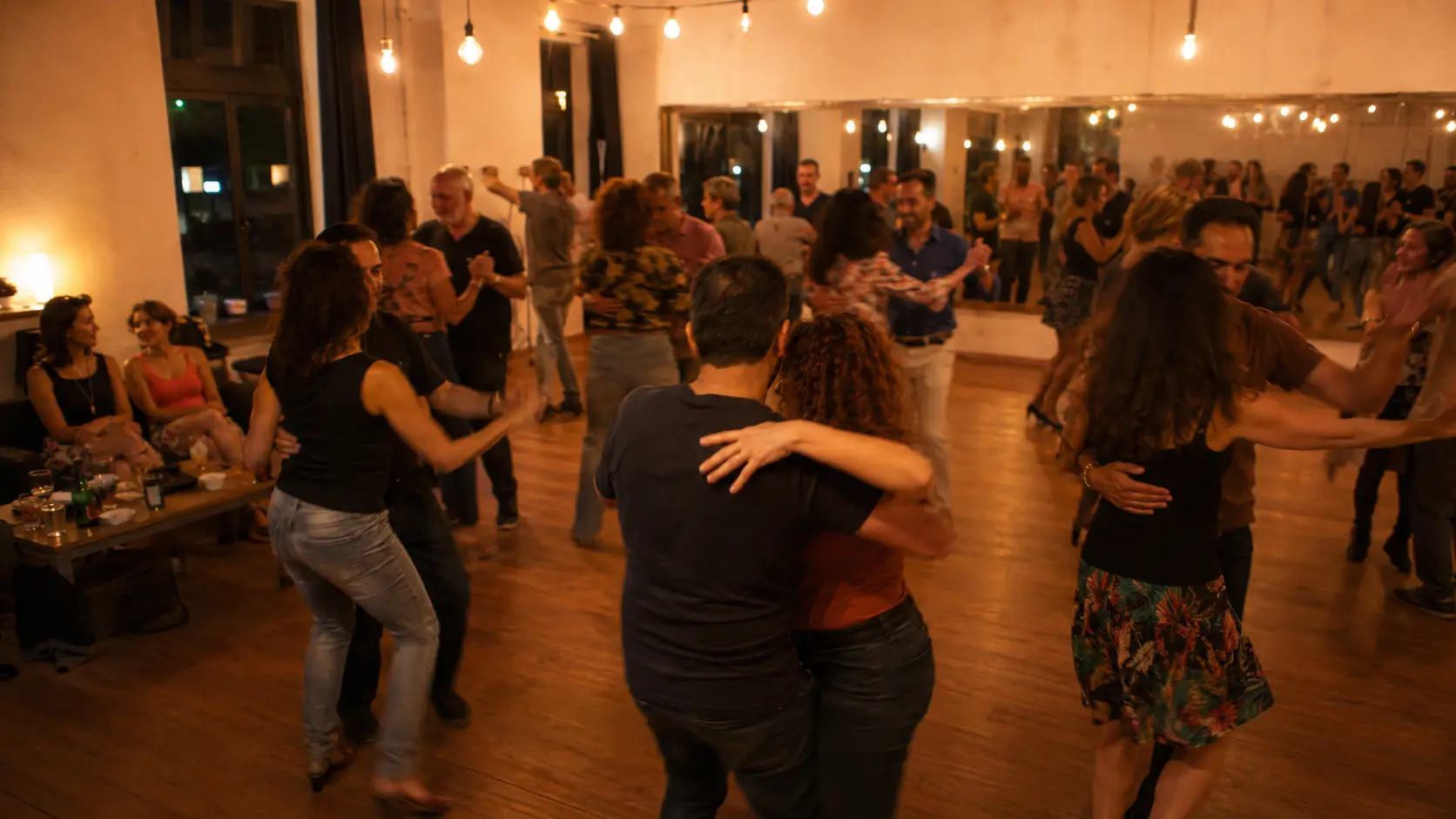 Evento de baile libre en Galidancia Vigo: parejas bailando en la pista de madera con luces cálidas y gente charlando sentada